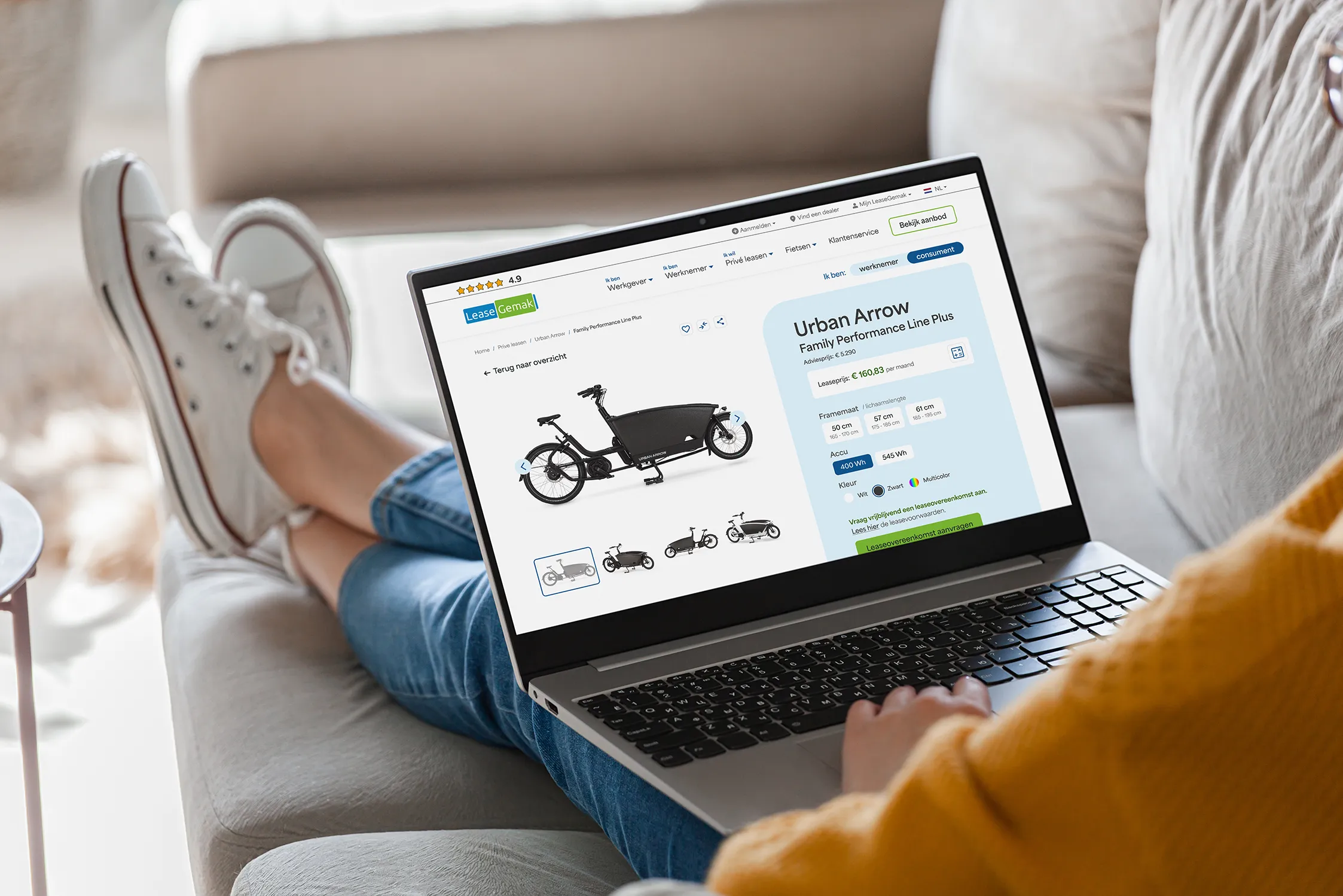 Vrouw met gestrekte benen op de bank, bekijkt op haar laptop een product detailpagina van een fiets op de website van LeaseGemak