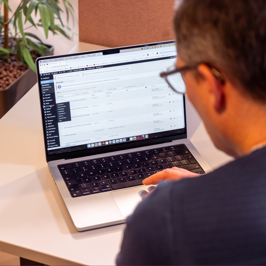 medewerker marketingbureau met op zijn bureau een laptop met wordpress erop.