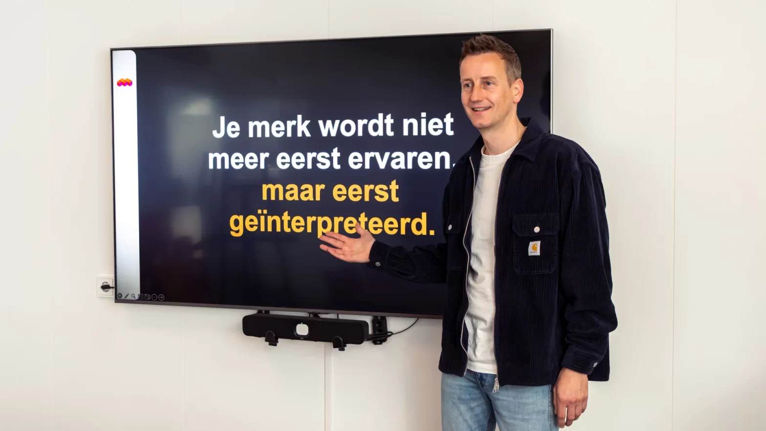 Martijn Eilander van Mixcom tijdens de kennissessie over AI en merkstrategie, wijzend naar de tekst 'Je merk wordt niet meer eerst ervaren, maar eerst geïnterpreteerd.